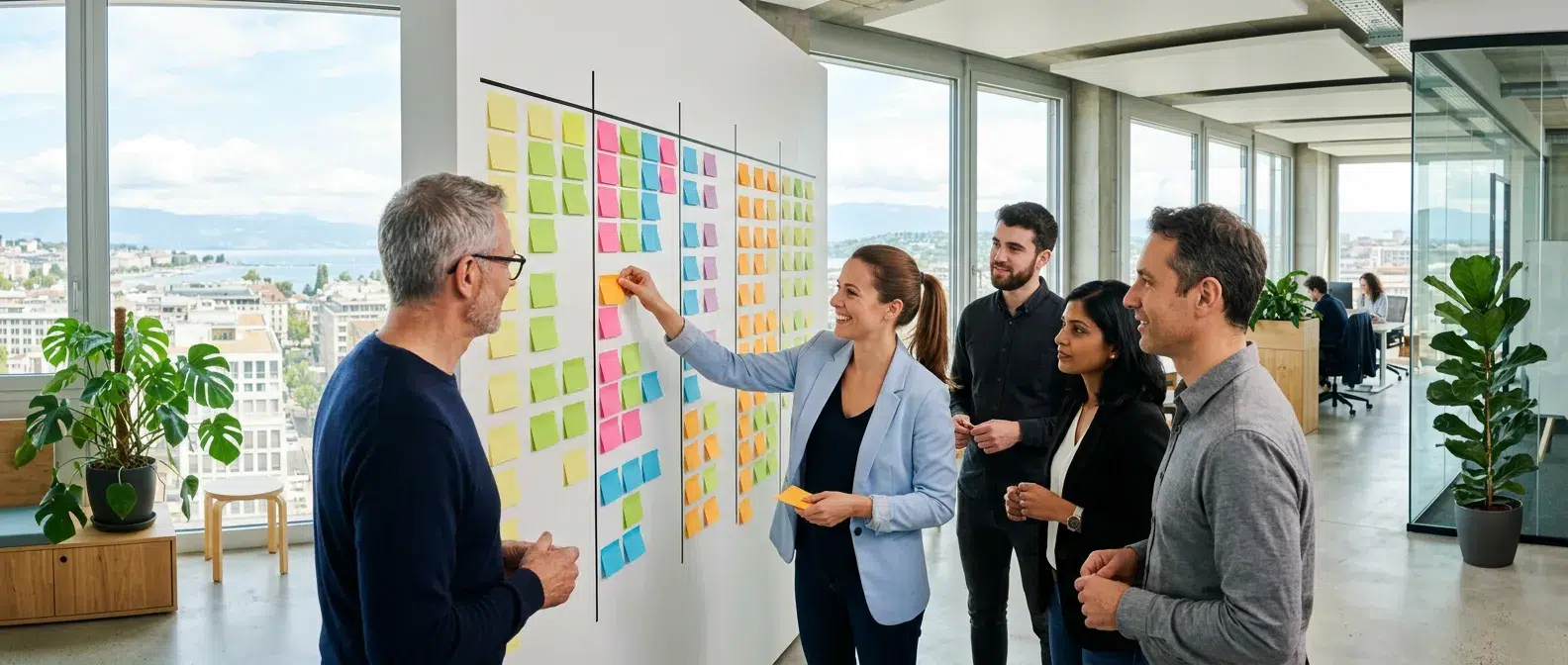 équipe Scrum réunie devant un tableau de tâches dans un bureau lumineux